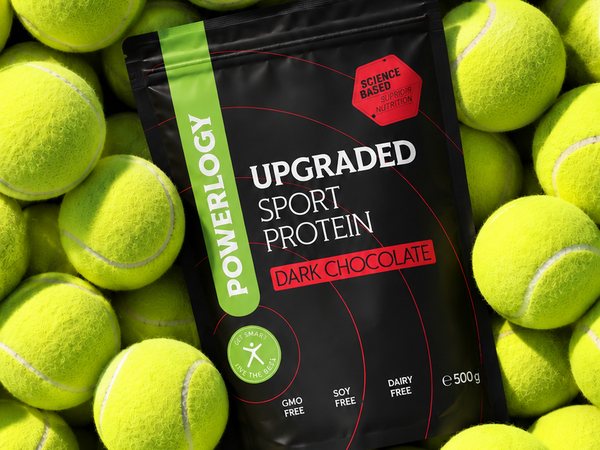 Sáček proteinu Powerlogy Upgraded Sport Protein na hromadě tenisových míčků